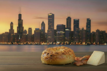 Bagel with bacon and cheese on a table with a city skyline in the background
